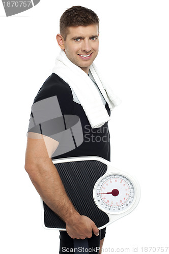Image of Healthy young man with a weight scale