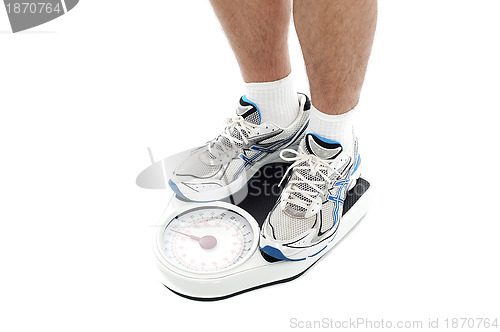 Image of Male person standing on weighing scale. Extreme closeup