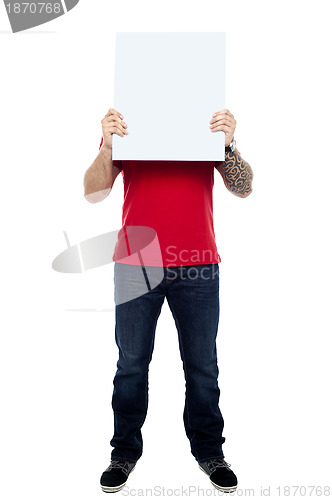 Image of Man hiding his face behind blank white ad board