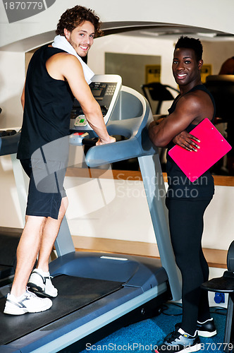 Image of Young african male trainer dedicated to his client