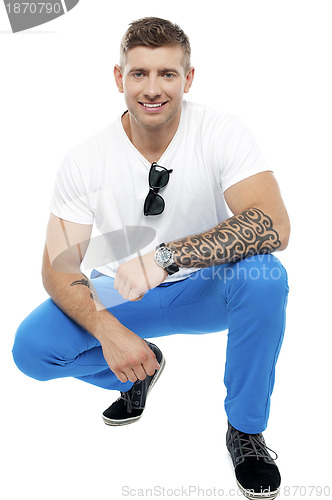Image of Tattooed man in squatting position