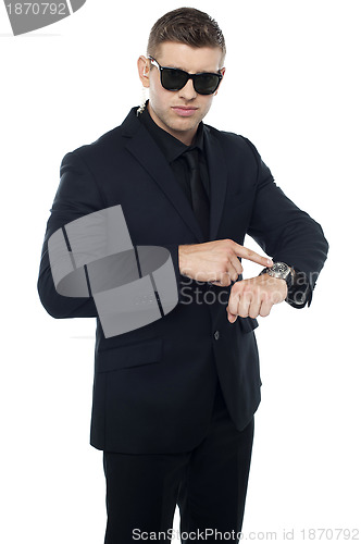 Image of Security official pointing at his watch