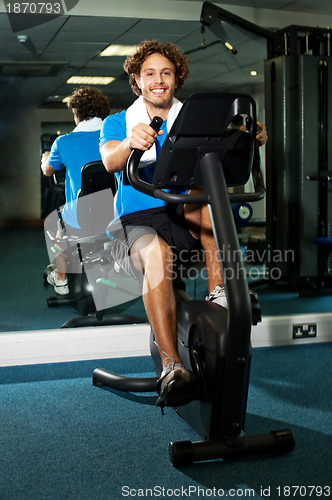 Image of Smart guy working out in the exercise bike