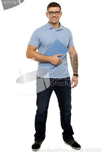 Image of Casual young guy holding notebook