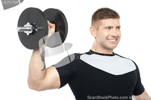 Image of Muscular male showing his biceps by lifting heavy dumbbell