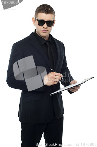 Image of Security officer writing on clipboard