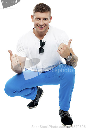 Image of Cheerful young man showing double thumbs up