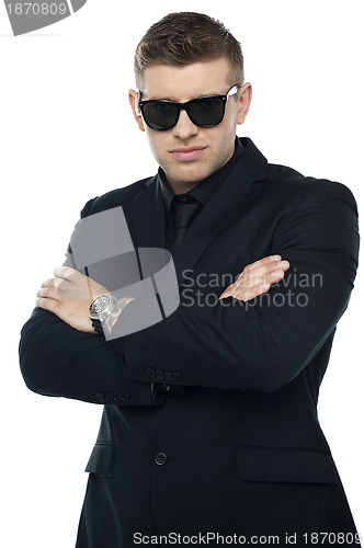 Image of Young stylish bouncer in a black suit, arms folded