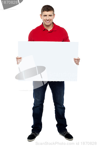 Image of Handsome guy presenting blank billboard to camera