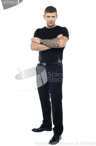 Image of Bodyguard with tattoo. Posing with folded arms