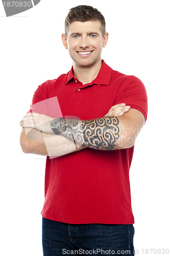 Image of Stylish man with tattoo on hand posing with folded arms