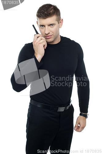 Image of Bouncer guy communicating with his walkie-talkie