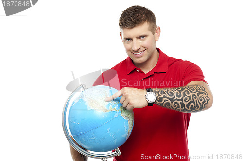 Image of Cool guy holding and pointing at the globe