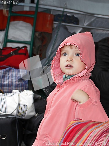 Image of Little girl among traffic baggage