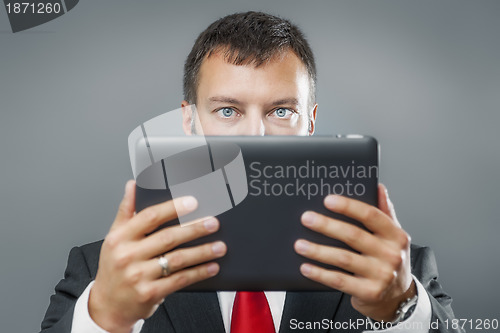 Image of business man reading tablet pc