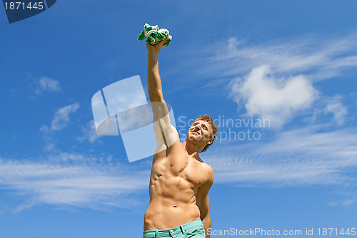 Image of Happy fit guy holding his t-shirt