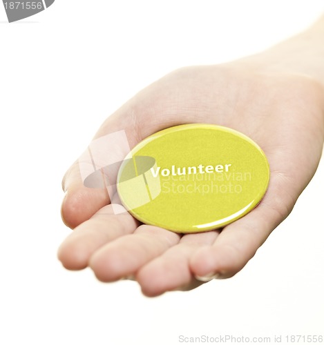 Image of Hand holding volunteer button