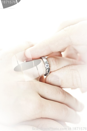 Image of Man putting engagement ring on finger