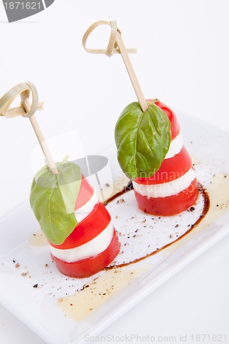 Image of tasty tomatoe mozzarella salad with basil on white 