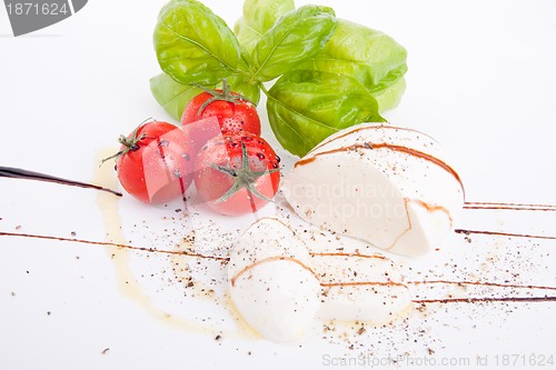 Image of tasty tomatoe mozzarella salad with basil on white 