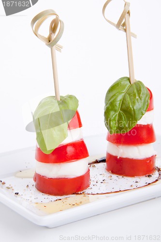 Image of tasty tomatoe mozzarella salad with basil on white 