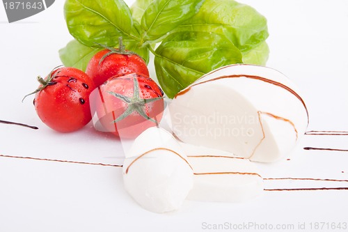 Image of tasty tomatoe mozzarella salad with basil on white 
