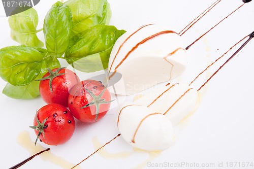 Image of tasty tomatoe mozzarella salad with basil on white 