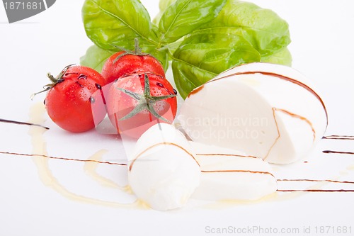 Image of tasty tomatoe mozzarella salad with basil on white 