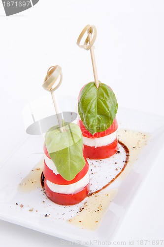 Image of tasty tomatoe mozzarella salad with basil on white 