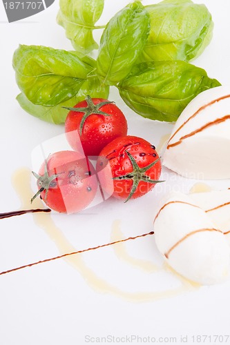 Image of tasty tomatoe mozzarella salad with basil on white 