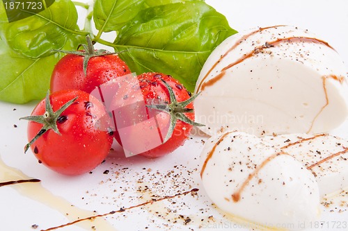 Image of tasty tomatoe mozzarella salad with basil on white 