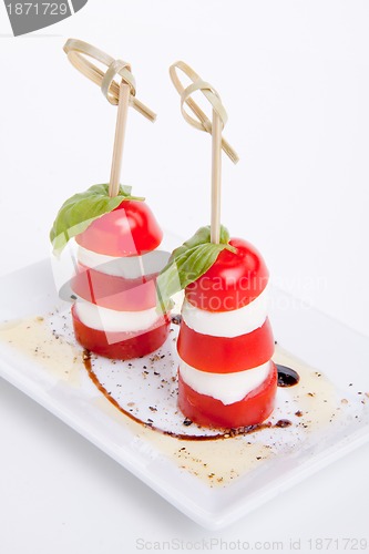 Image of tasty tomatoe mozzarella salad with basil on white 