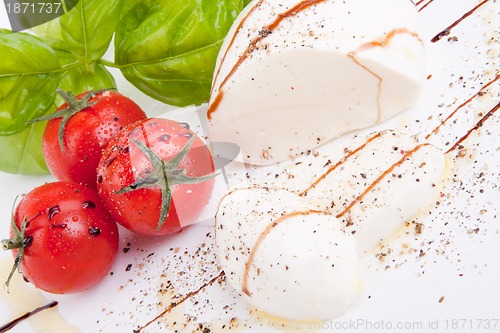 Image of tasty tomatoe mozzarella salad with basil on white 