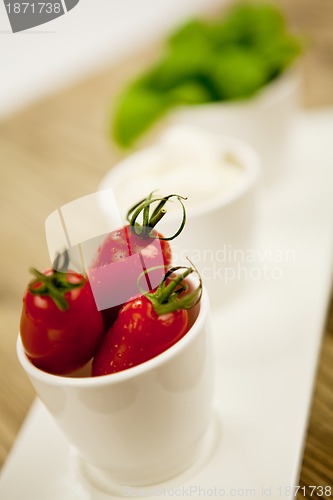 Image of tasty tomatoes mazarella and basil on plate on table
