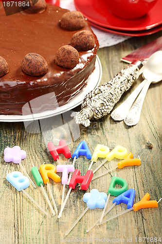 Image of Chocolate cake and candles in the form of letters.
