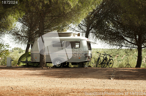 Image of Small white caravan through the trees
