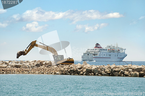 Image of Building a dike. Excavator put stones