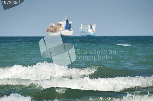Image of Commercial container ship on blue sky
