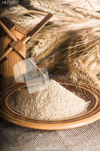 Image of Wholemeal flour and wheat on cloth sack, close-up