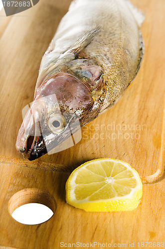 Image of Pike perch on a wooden kitchen board, it is isolated on white