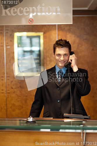 Image of Profile shot of a handsome receptionist on the phone