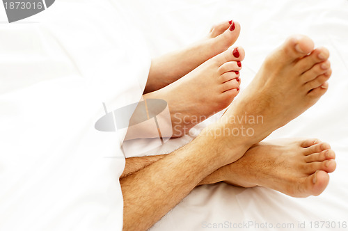 Image of Closeup of bare feet of love couple, making out