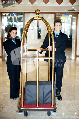 Image of Concierge colleagues holding baggage cart