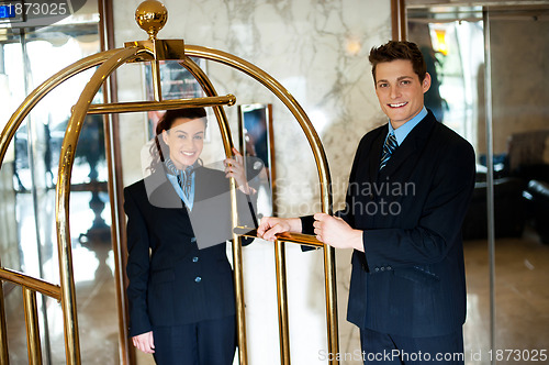 Image of Concierges holding the cart and posing