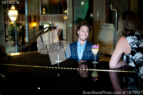 Image of Couple enjoying soothing music as guy plans piano