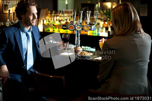 Image of Attractive couple refreshing themselves at the bar