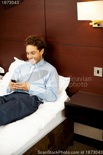 Image of Cool businessman sending out messages to his friends