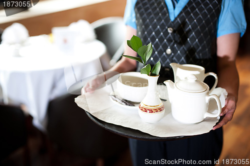 Image of Cropped image of a woman holding tea tray