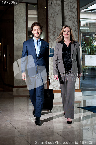 Image of Confident business colleagues entering hotel lobby
