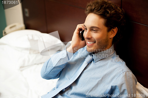 Image of Young man conversing on mobile phone